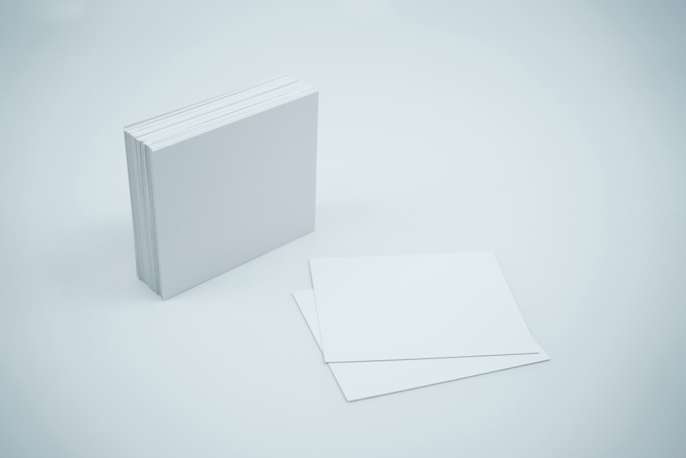 a white book with a blank cover next to it