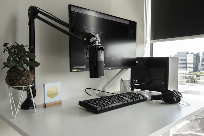 a desk with a computer monitor, keyboard and mouse