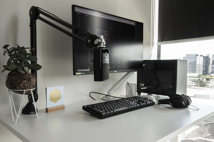 a desk with a computer monitor, keyboard and mouse