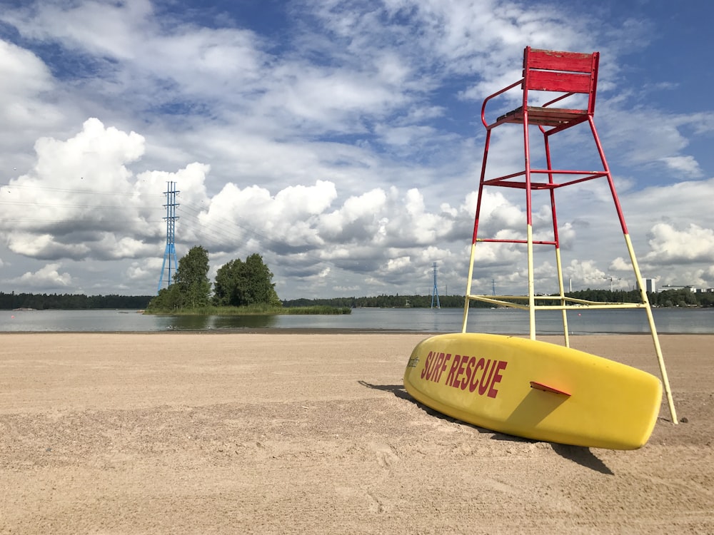 a lifeguard stand with a surfboard on the beach