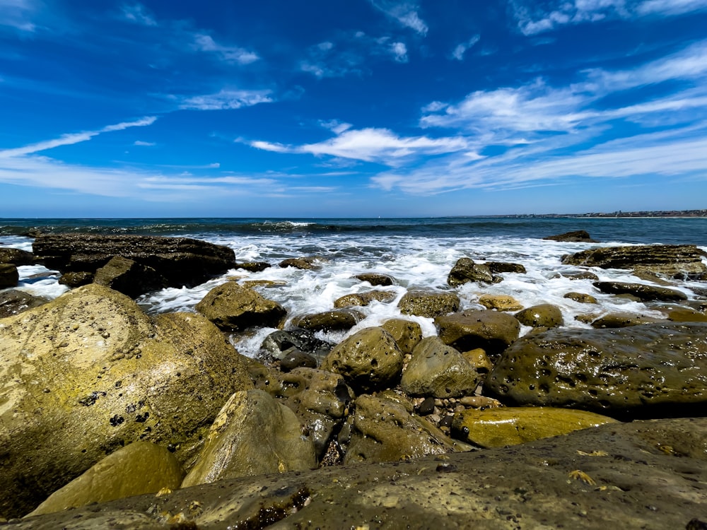 a rocky beach with waves crashing on the rocks