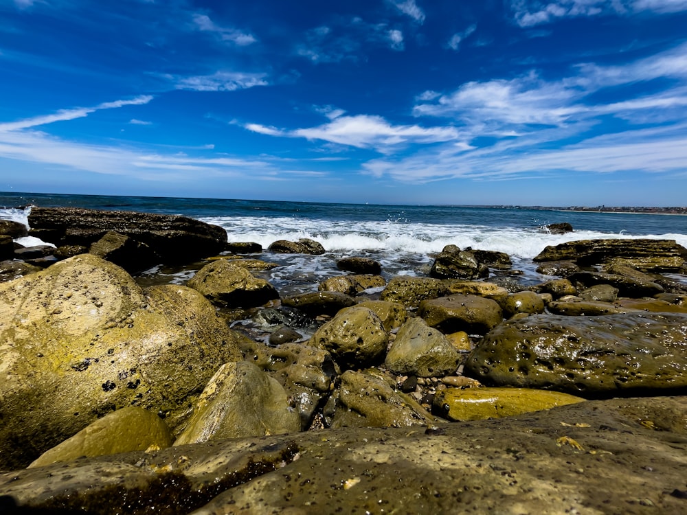 a rocky beach with a body of water in the distance