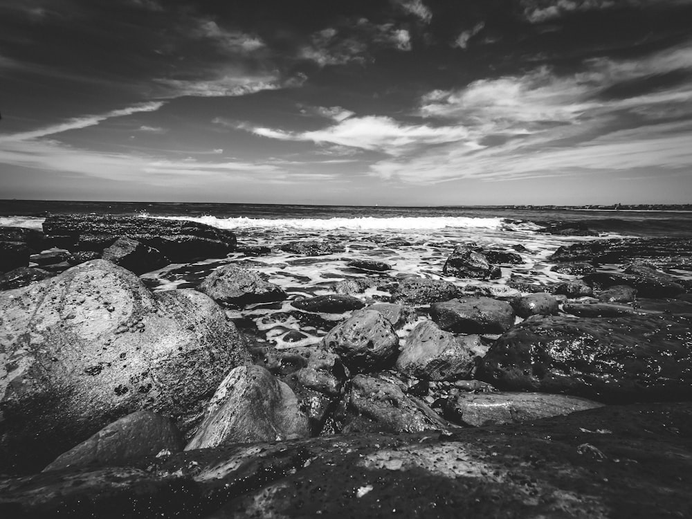 a black and white photo of rocks and water