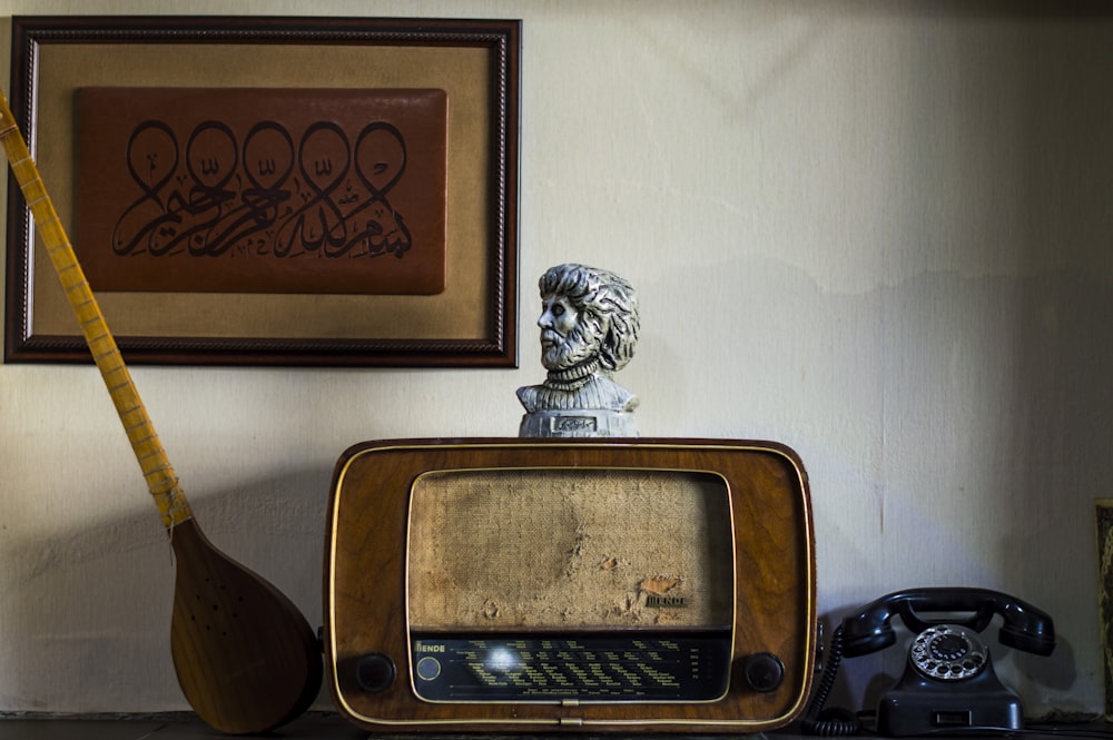 an old tv sitting on top of a table next to a guitar