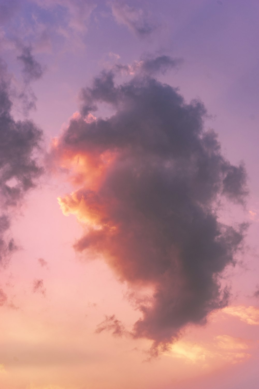 a plane flying in the sky at sunset