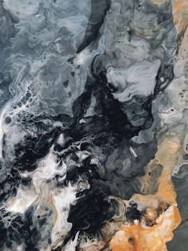 Artistic resin floor with swirling patterns in gray, black, and gold tones.