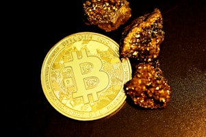 a bitcoin sitting on top of a pile of gold nuggets
