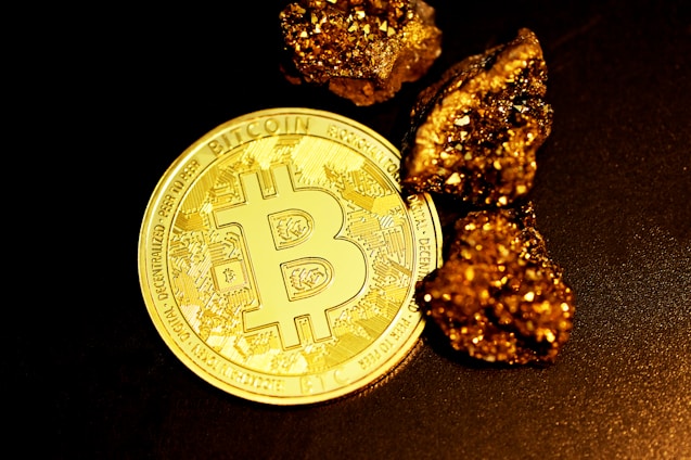 a bitcoin sitting on top of a pile of gold nuggets
