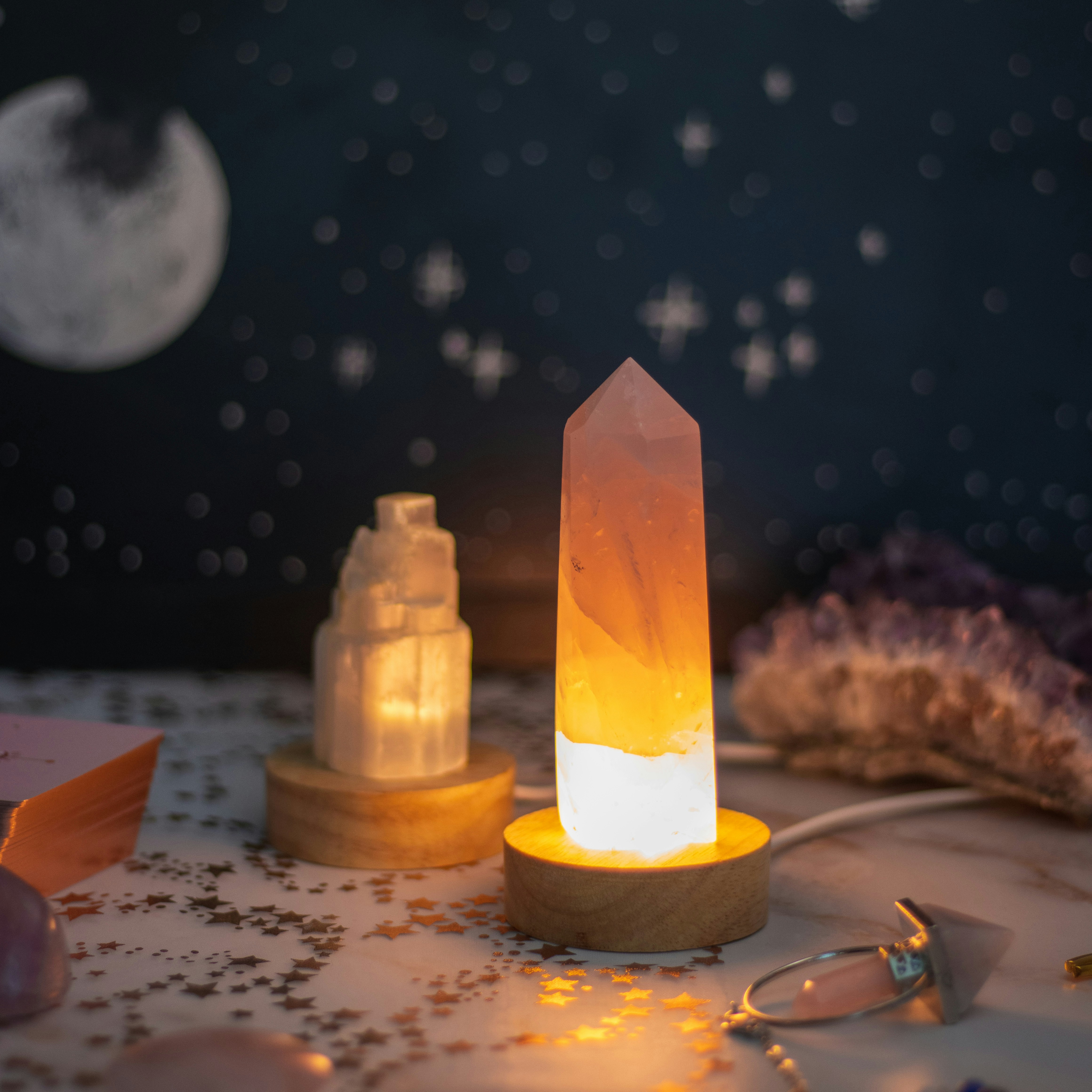 Two glowing crystal lamps sit on a table decorated with stars.