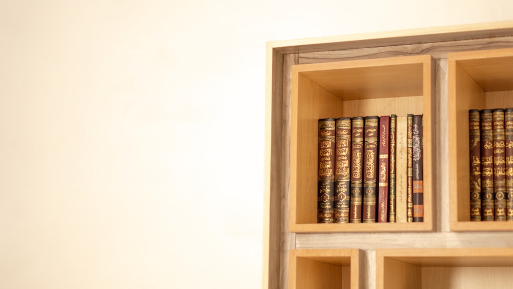 uma estante cheia de muitos livros ao lado de uma parede