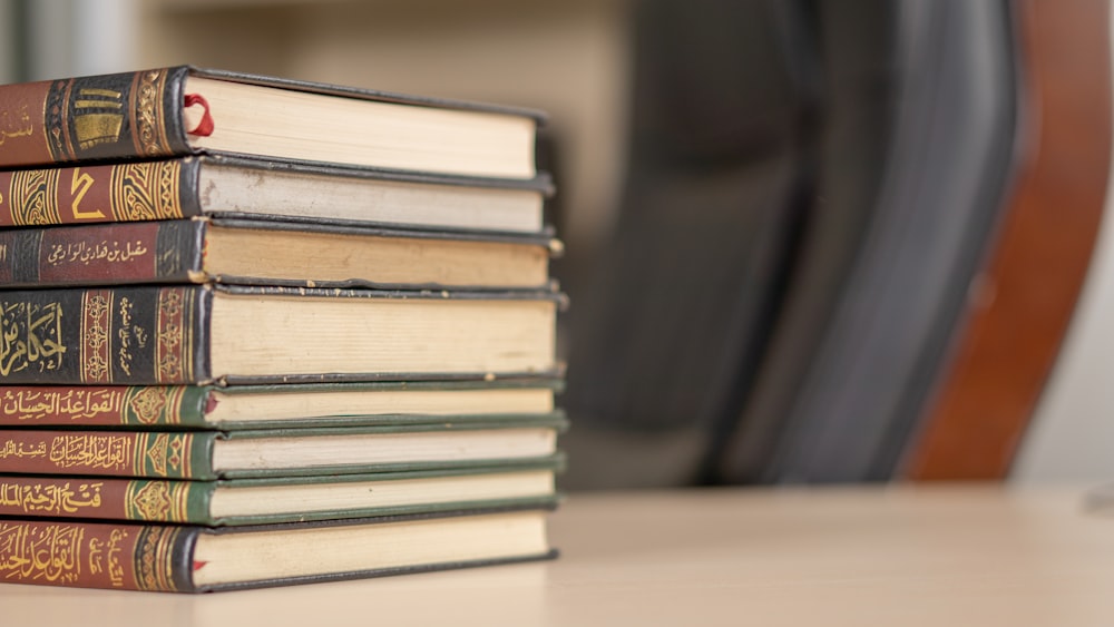 uma pilha de livros sentados em cima de uma mesa