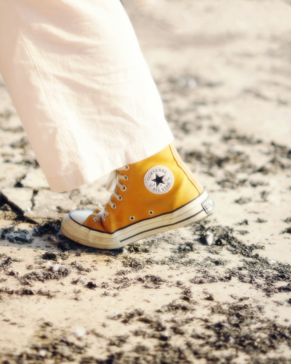 a person wearing yellow converses with a white eye