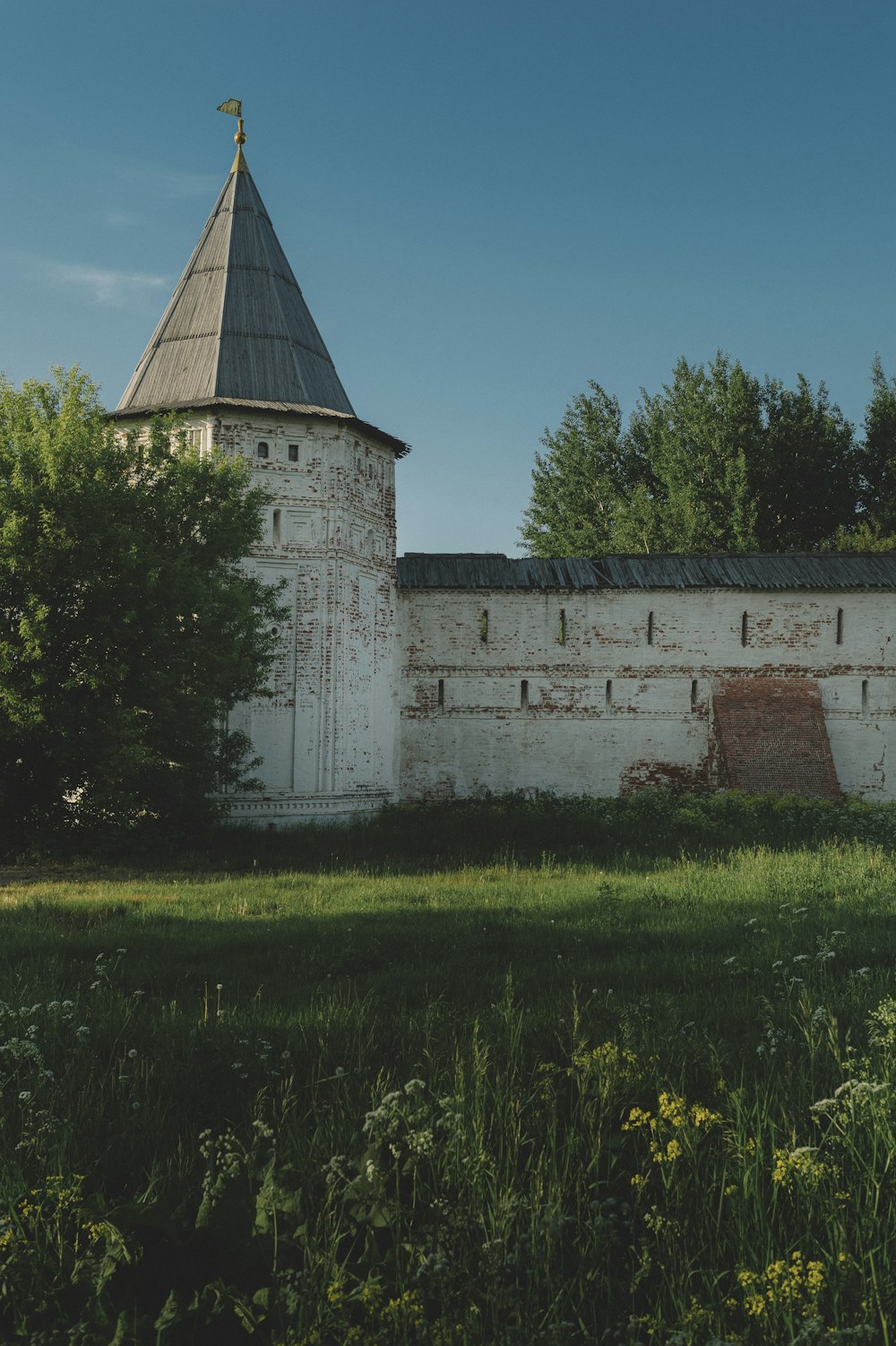 an old white building with a steeple on top of it