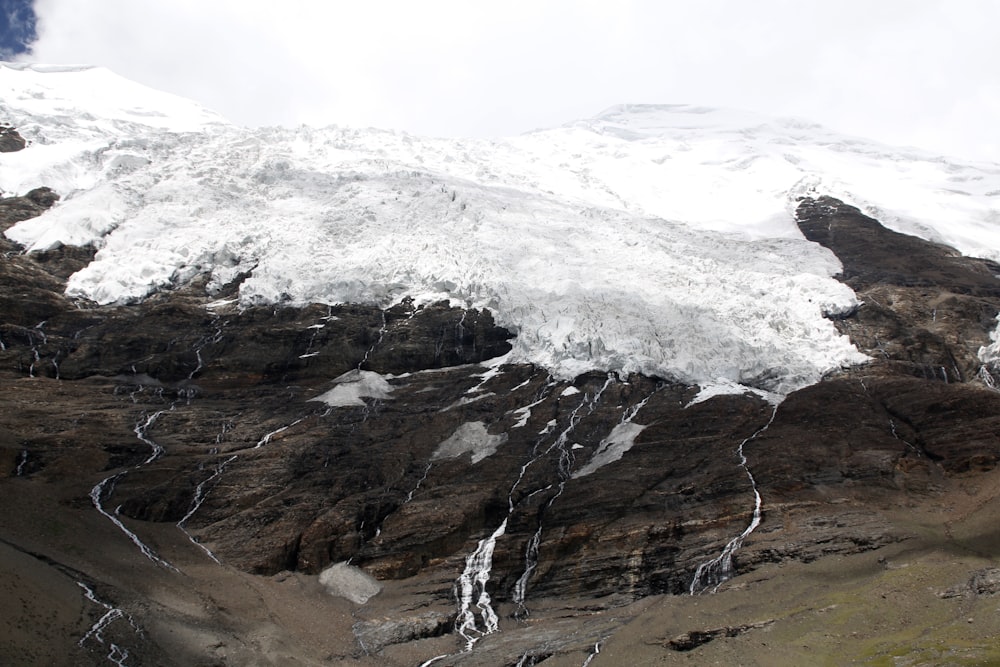 a snow covered mountain with a stream of water