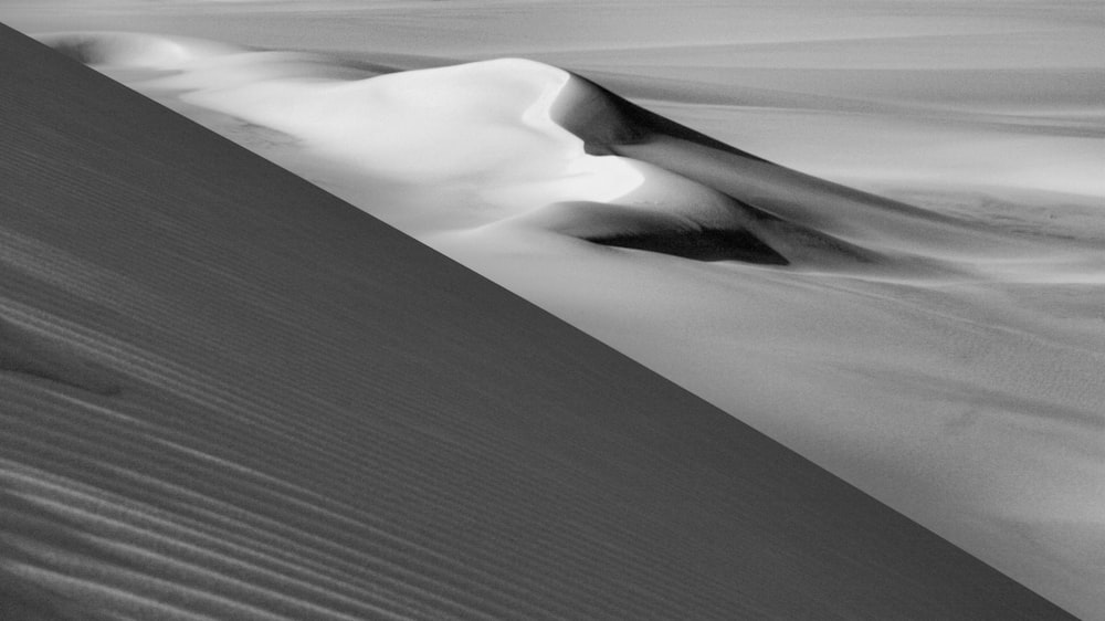 a black and white photo of a sand dune