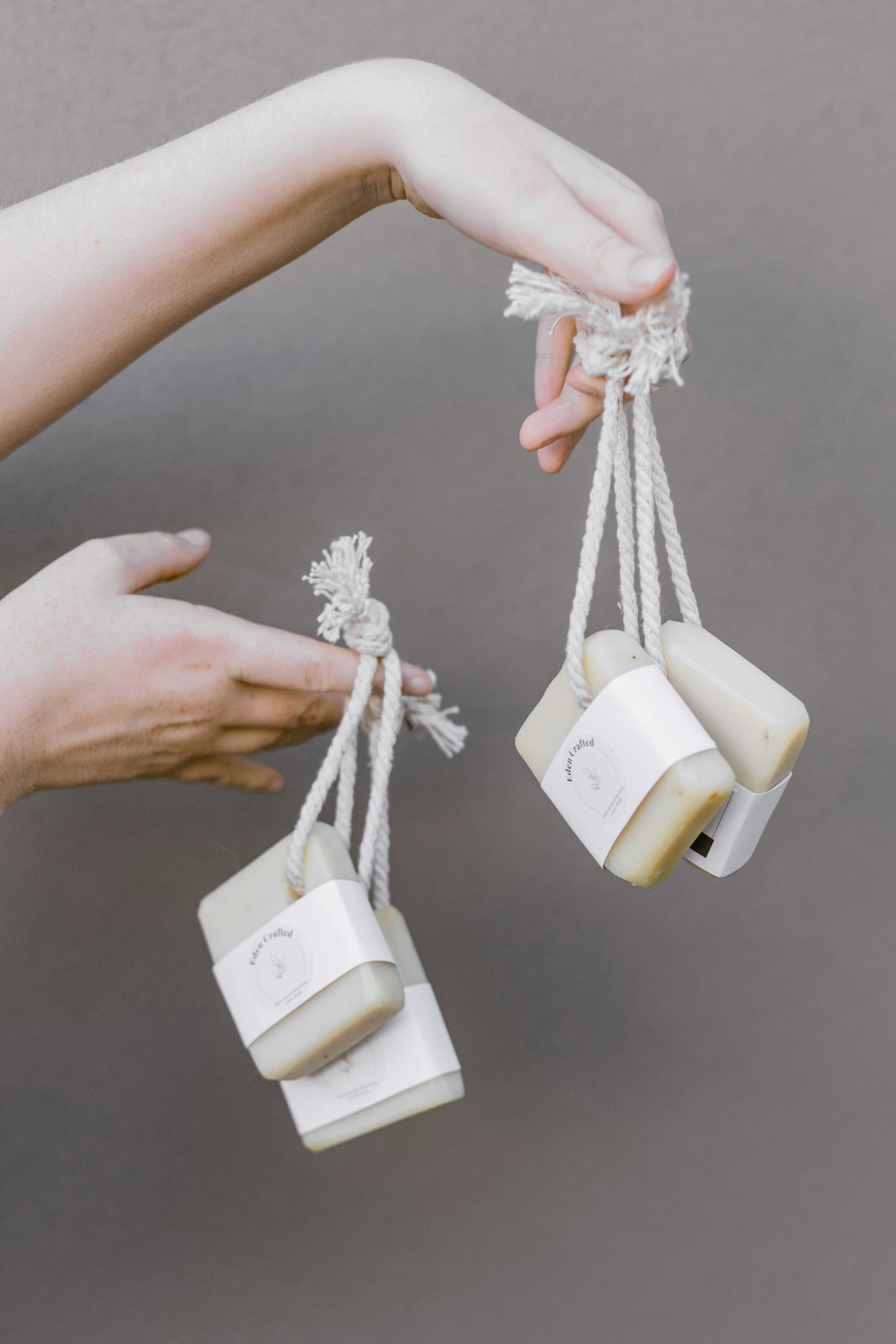 a person holding three soaps in their hands