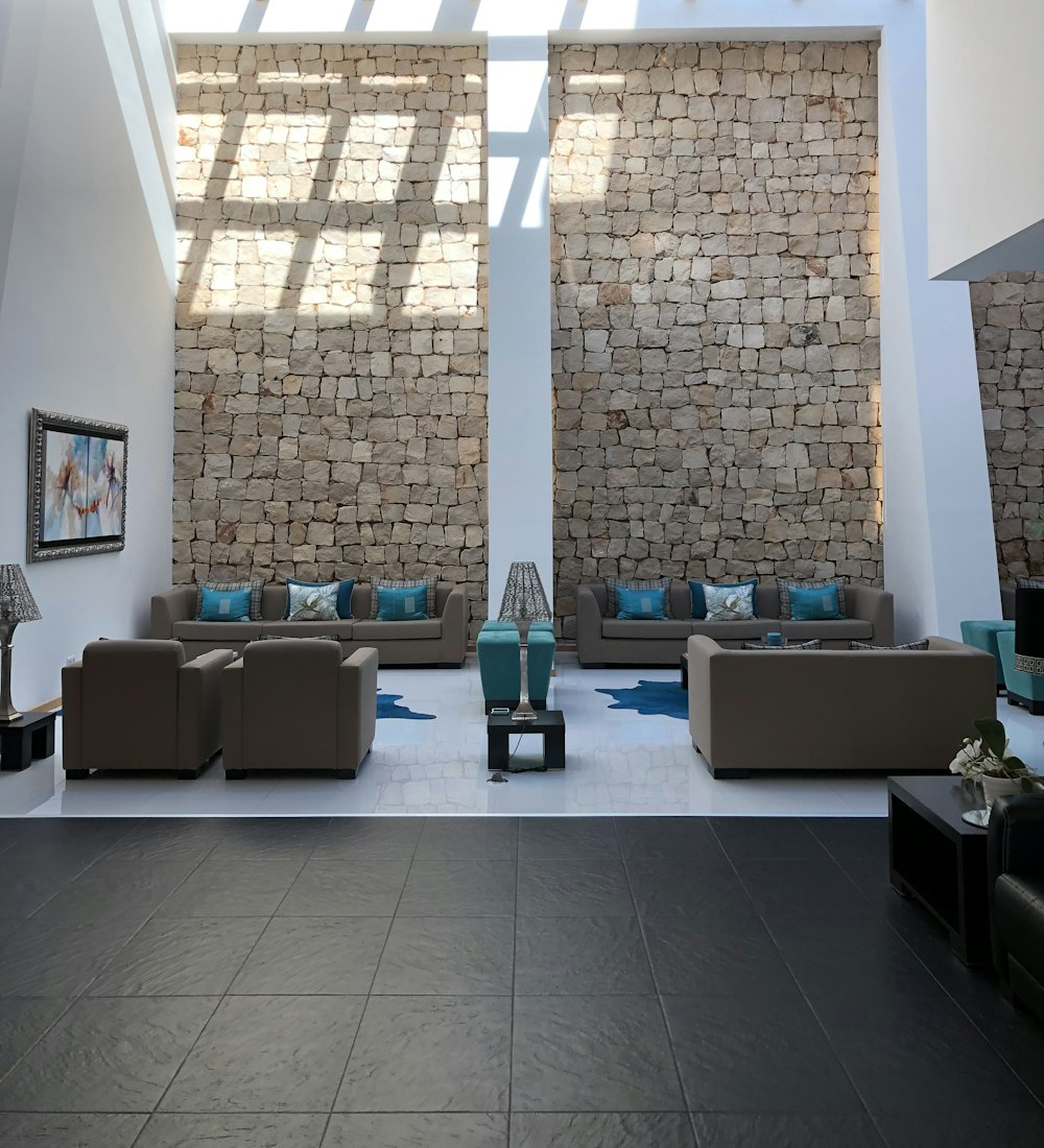 una sala de estar con dos sofás y una pared de piedra