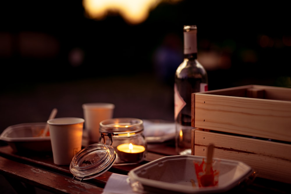 a wooden table topped with plates and cups