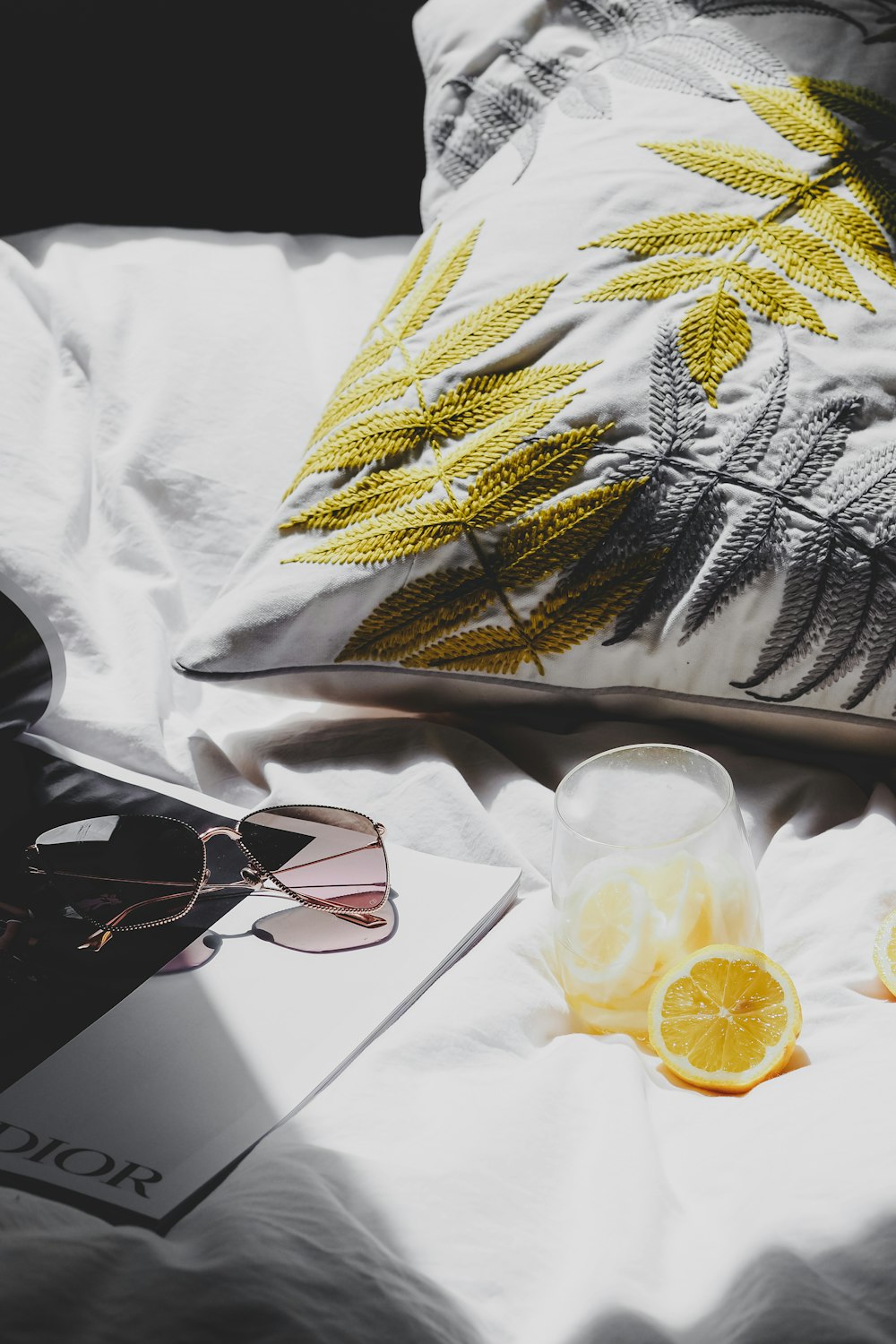 a pair of sunglasses sitting on top of a bed