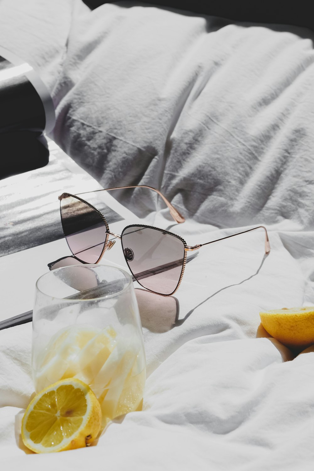 a pair of sunglasses sitting on top of a bed