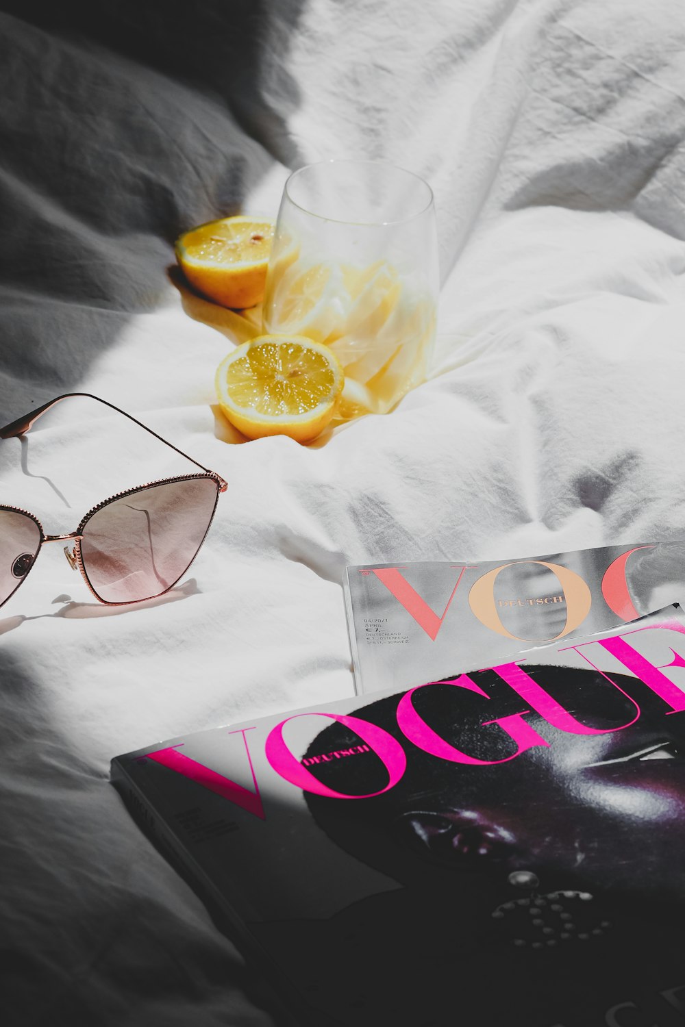 a pair of sunglasses and a book on a bed