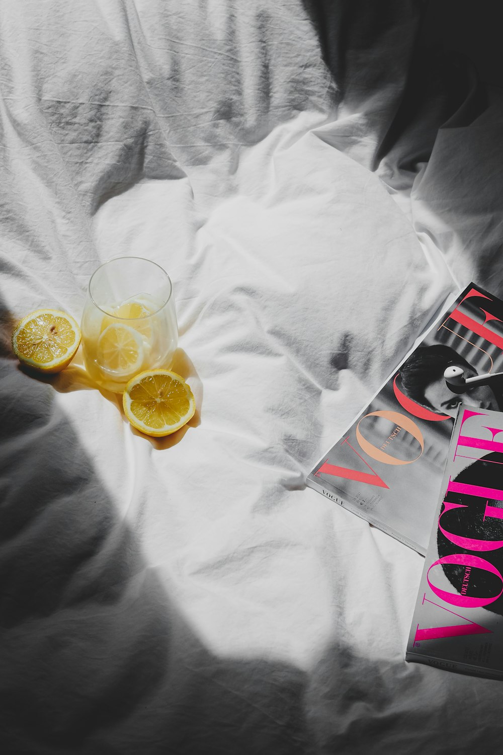 Un libro y un vaso de jugo de naranja en una cama