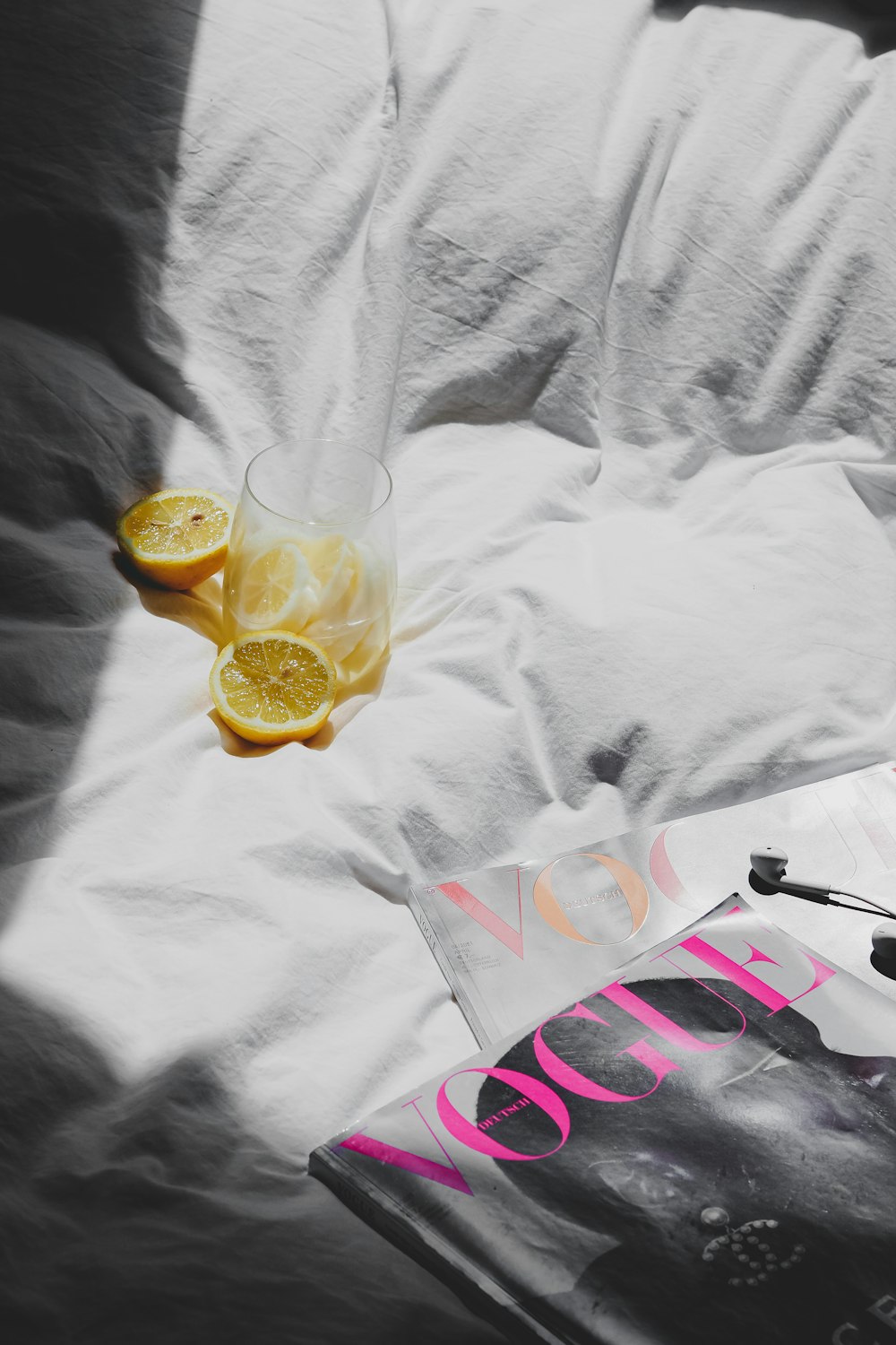 a glass of lemonade and a magazine on a bed