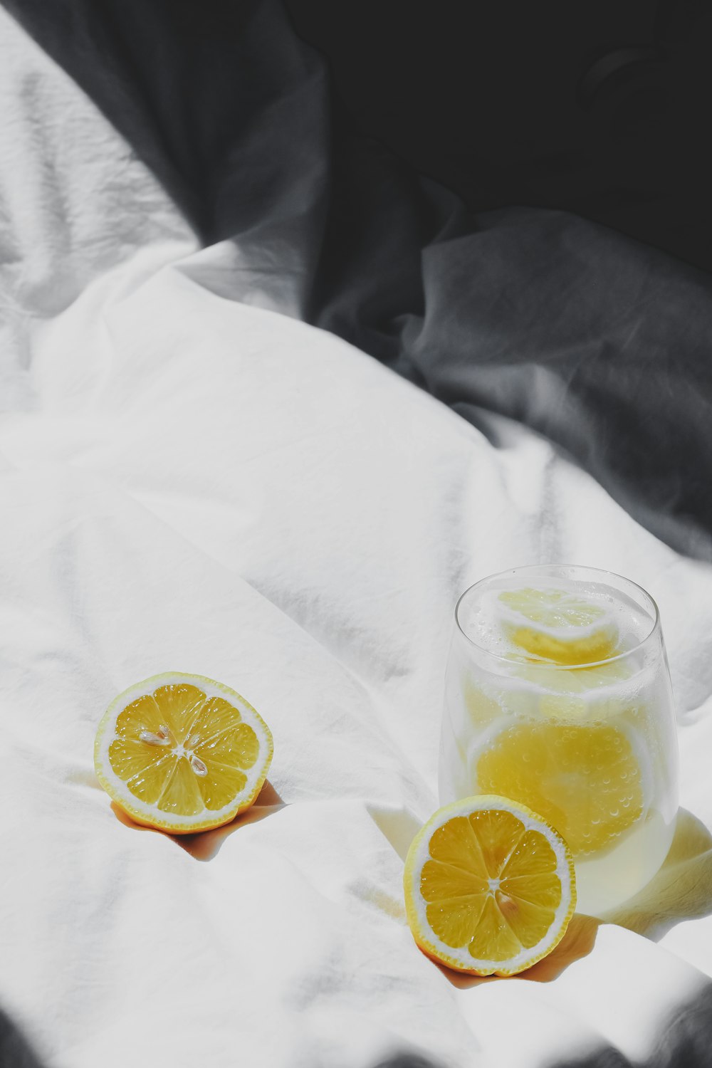 a glass of lemonade sitting on top of a bed