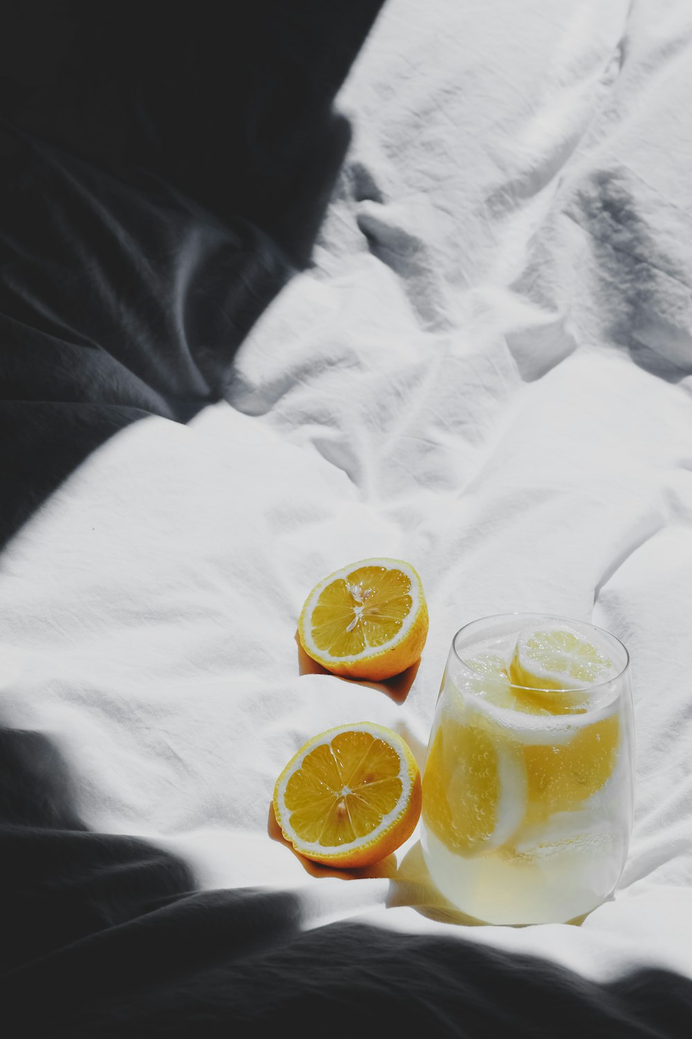 a glass of lemonade sitting on top of a bed