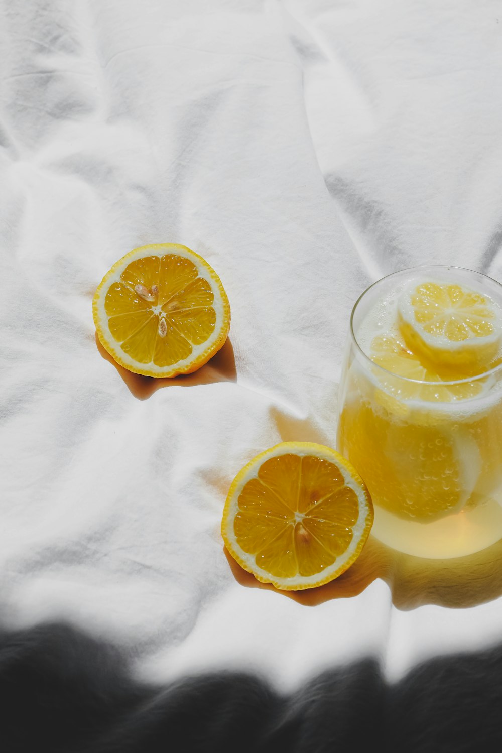 a glass of orange juice with two slices of orange