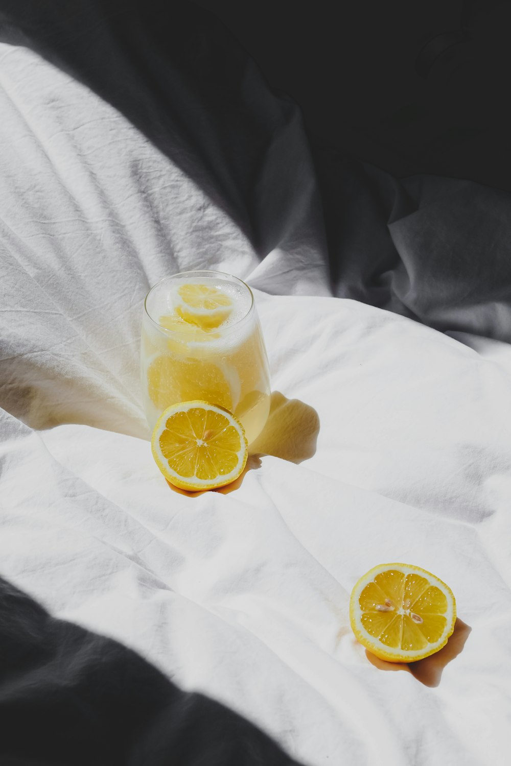 un bicchiere di succo d'arancia seduto sopra un letto
