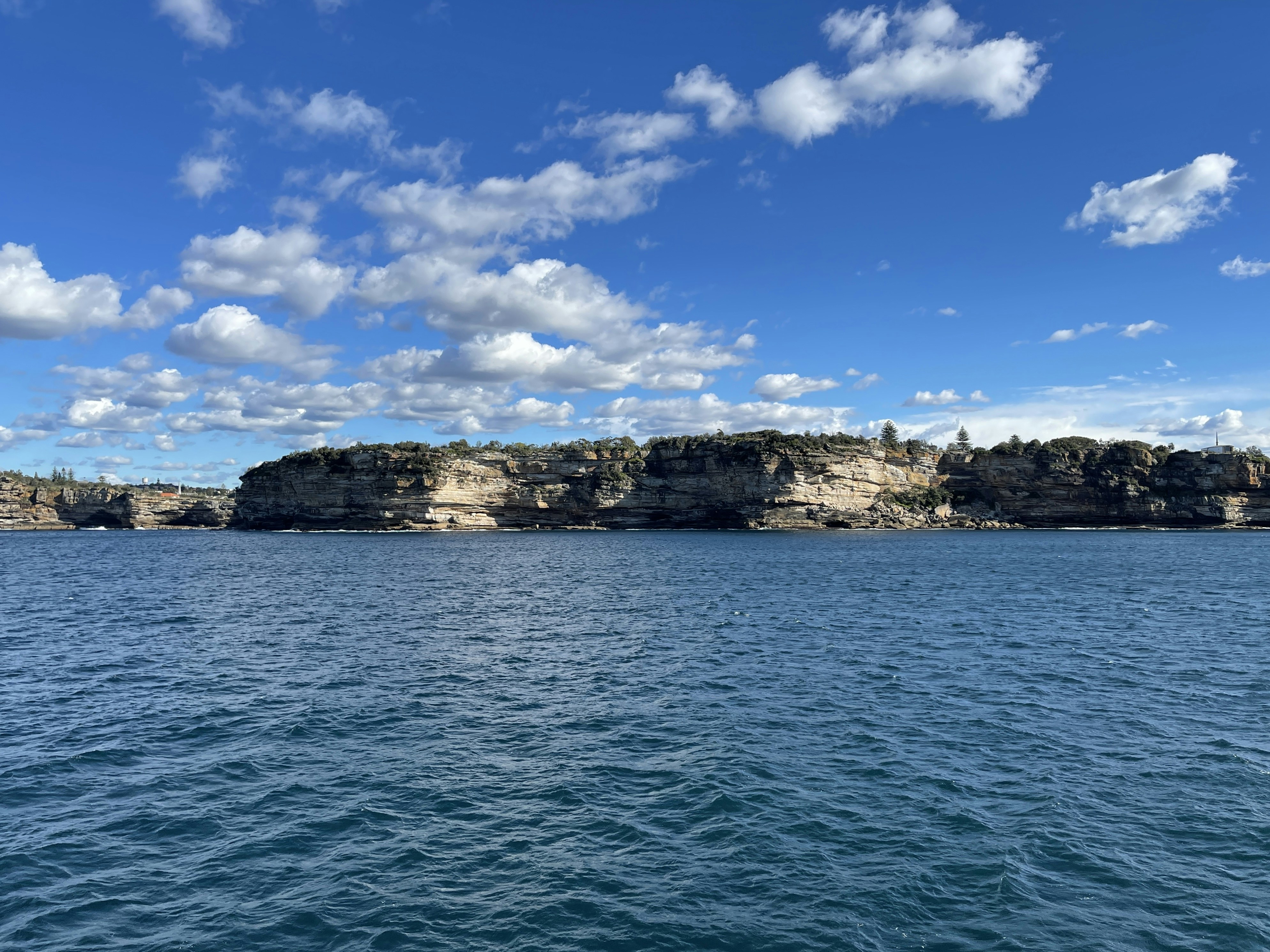 a large body of water with rocks in the background