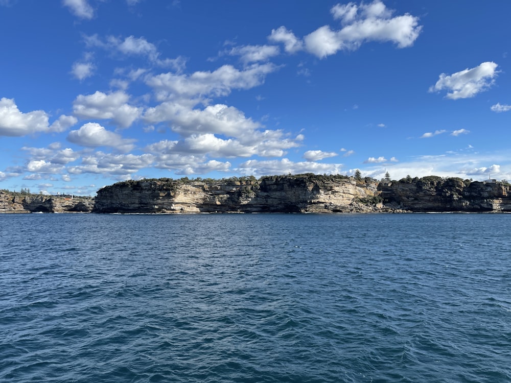 a large body of water with rocks in the background