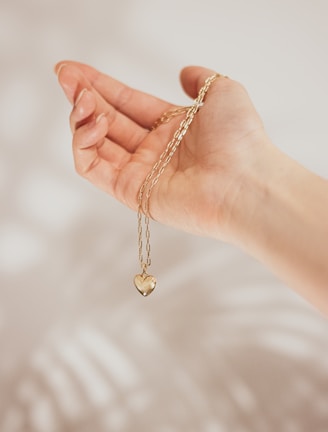 Close-up of a delicate gold necklace engraved with a heartfelt message.