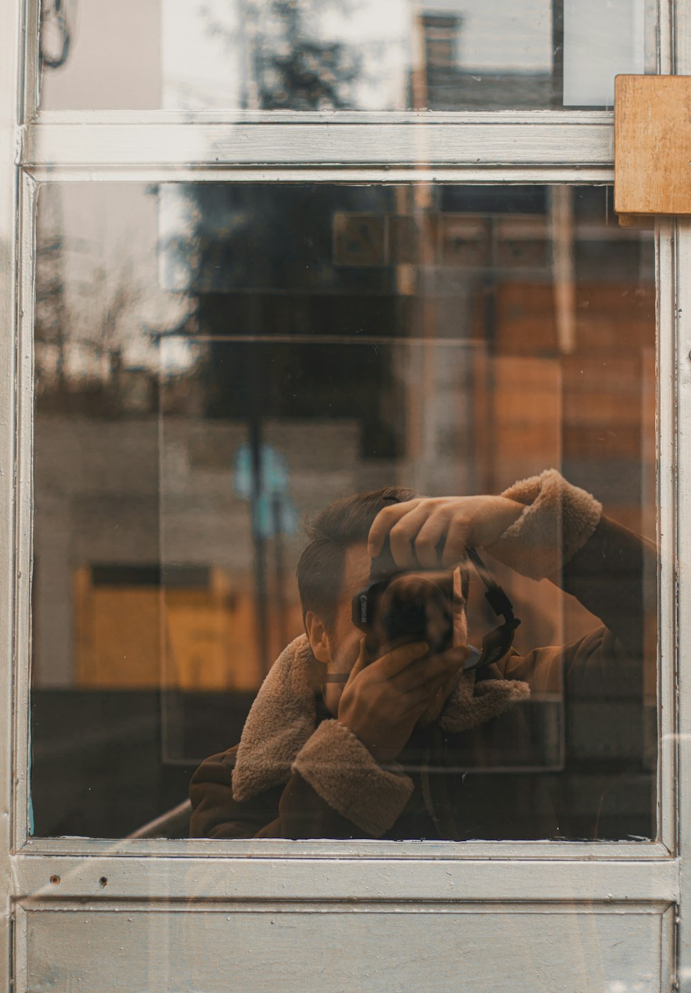 a man taking a picture of himself in a window