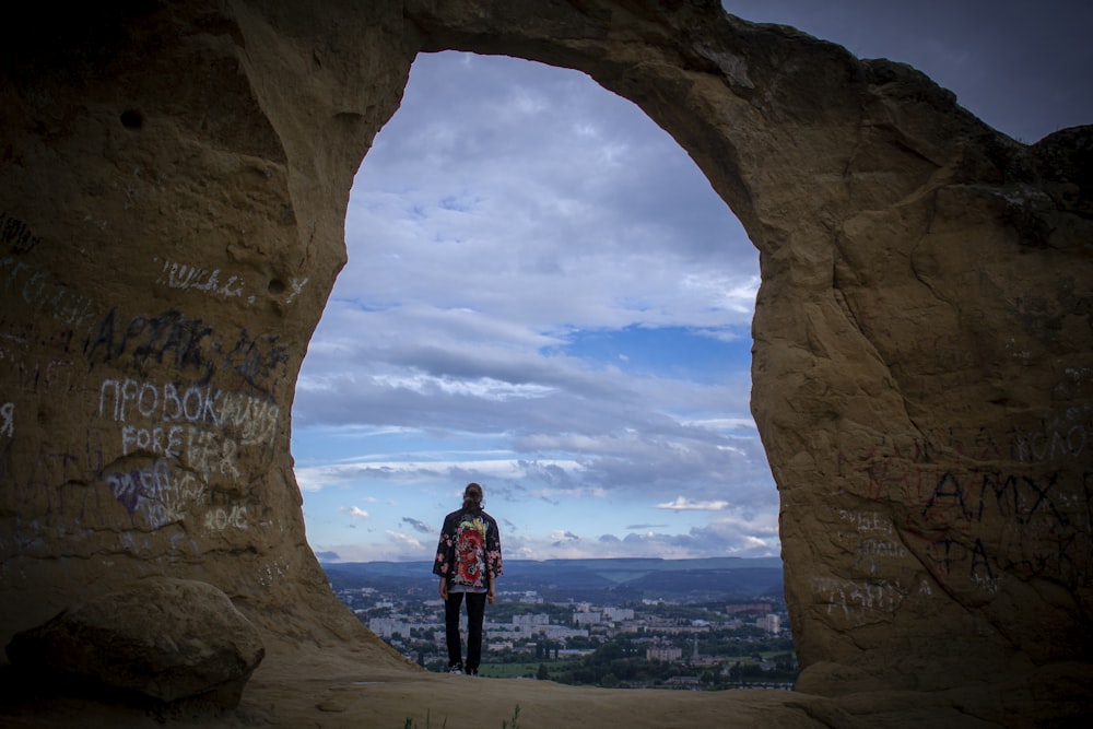 Eine Person, die in einer Höhle mit Graffiti darauf steht