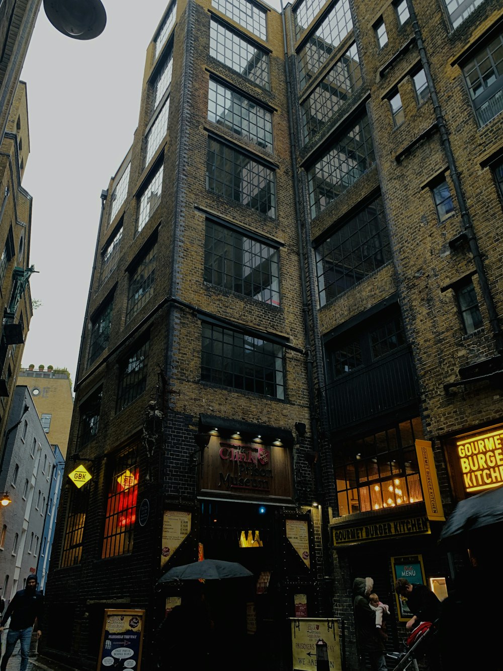 a group of people walking down a street next to tall buildings