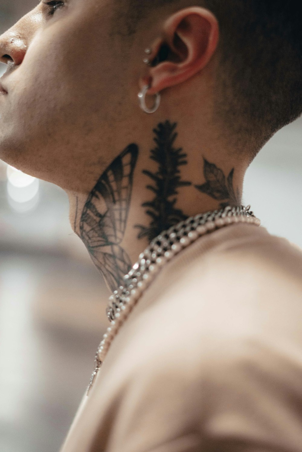 a man with a butterfly tattoo on his neck