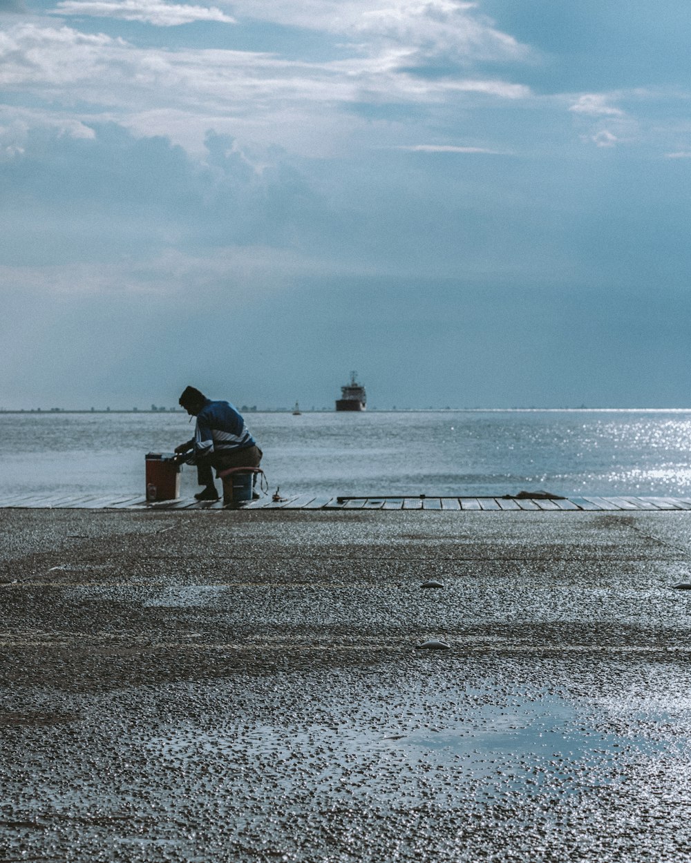 a man sitting on a bench on the beach