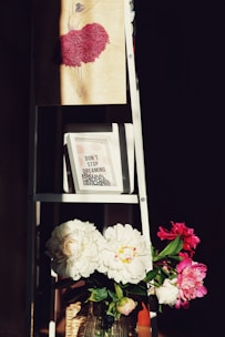 a ladder with a vase of flowers on top of it