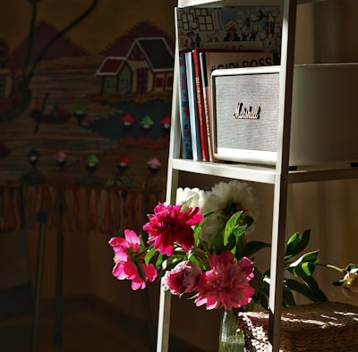 a shelf with a vase of flowers on top of it