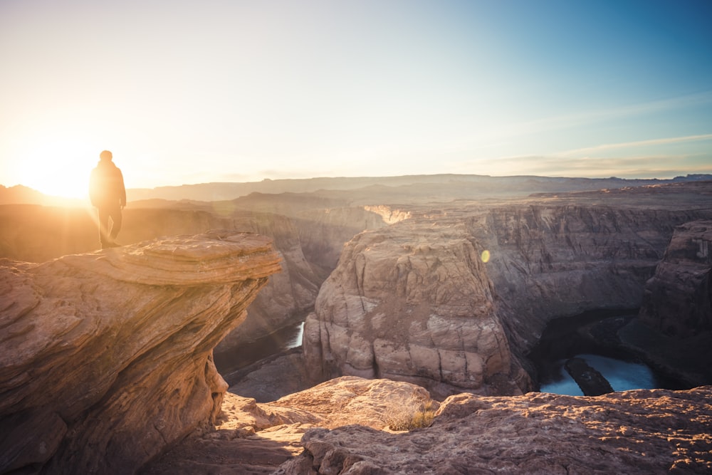 a person standing on top of a large cliff