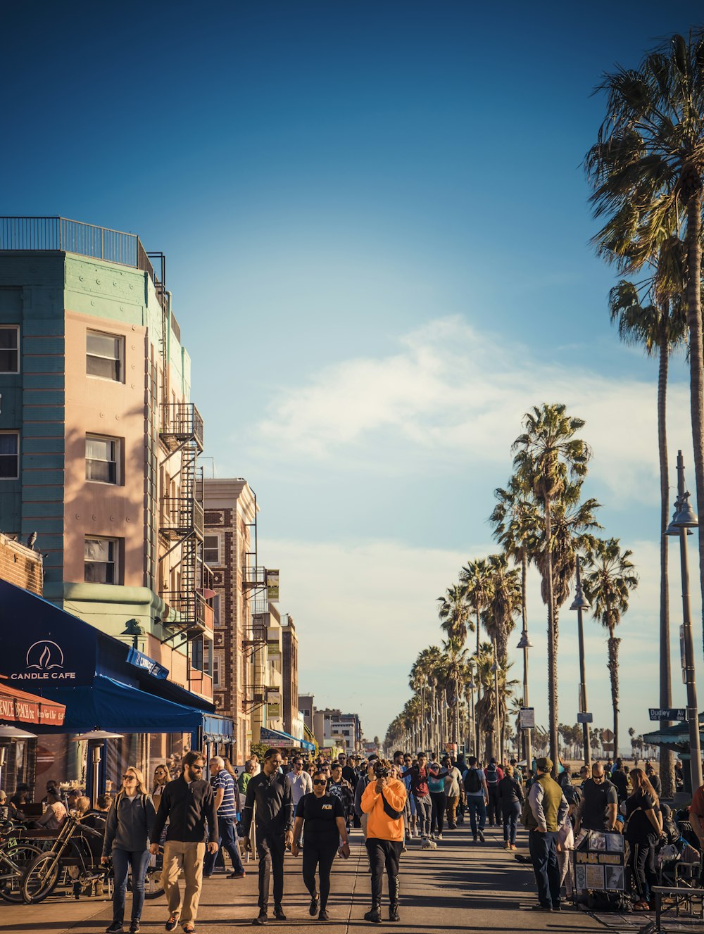 a crowd of people walking down a street next to tall buildings