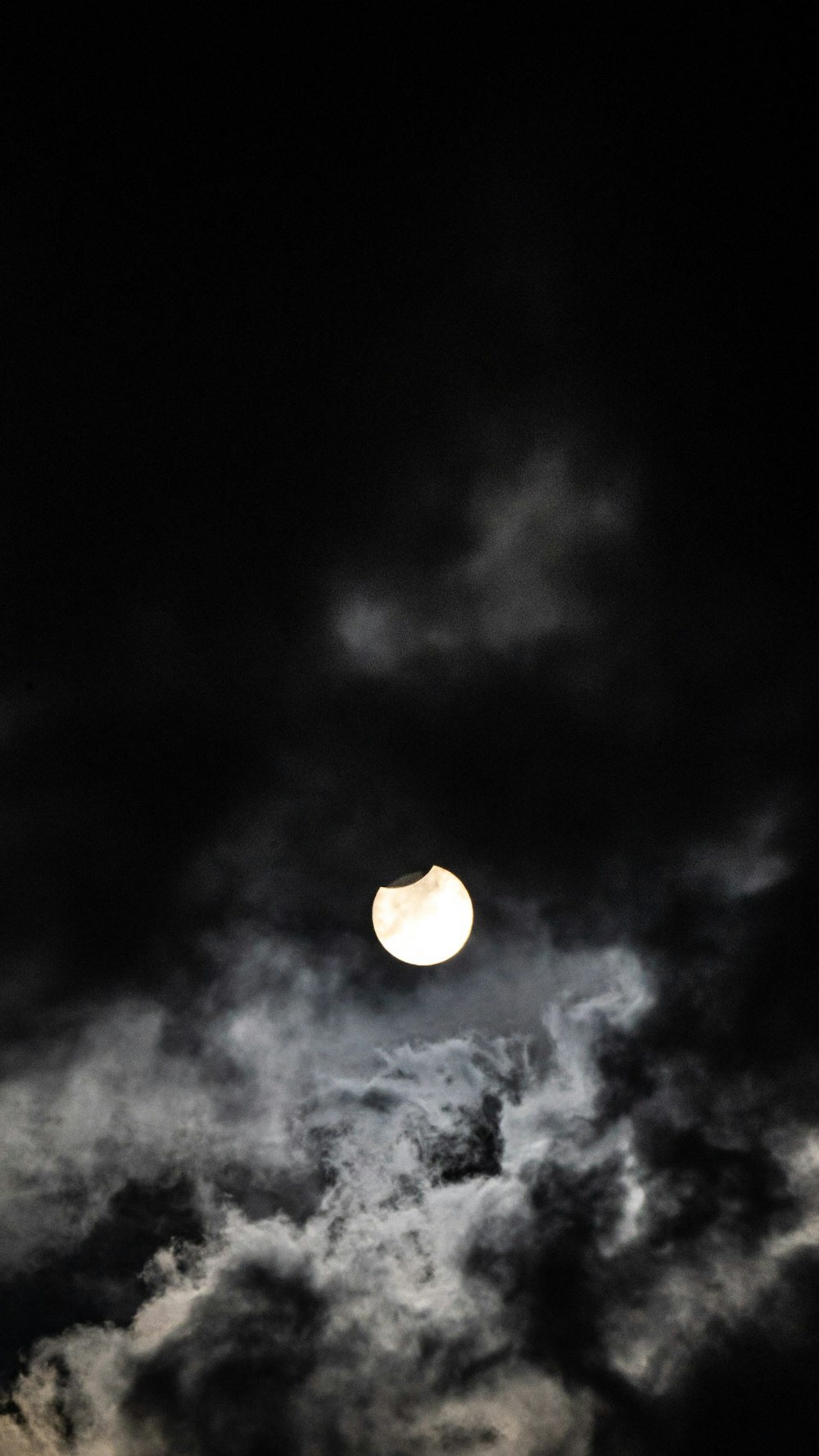 Der Mond ist durch die dunklen Wolken gesehen