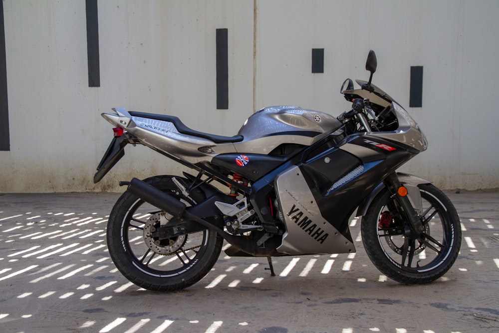 a silver and black motorcycle parked in front of a building