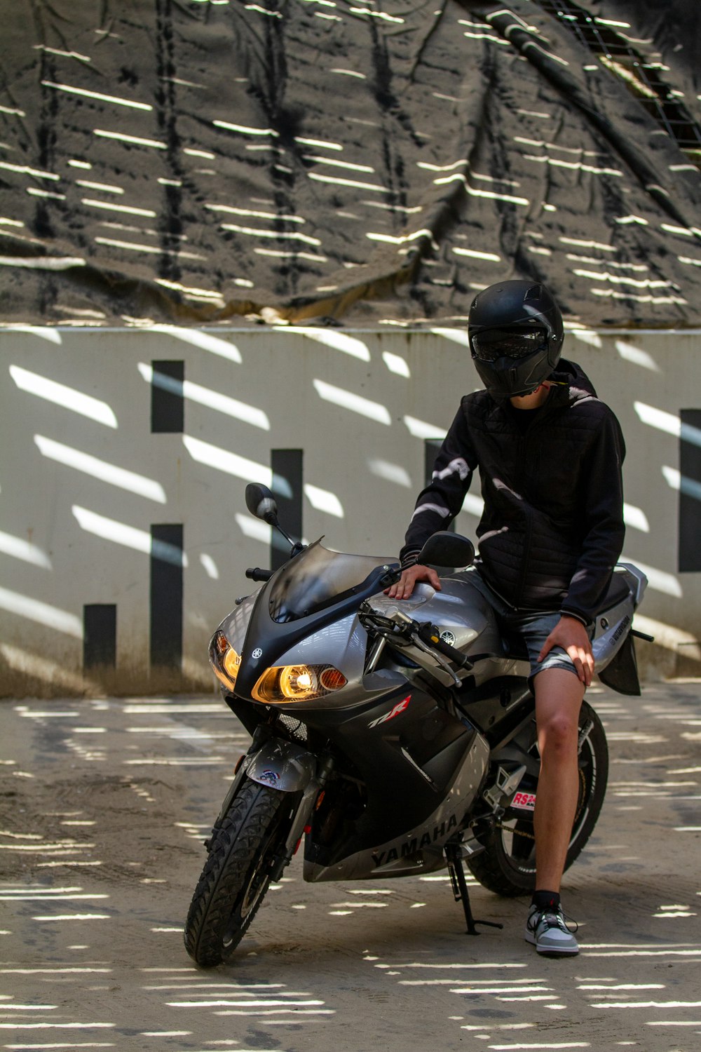 a man sitting on top of a black motorcycle