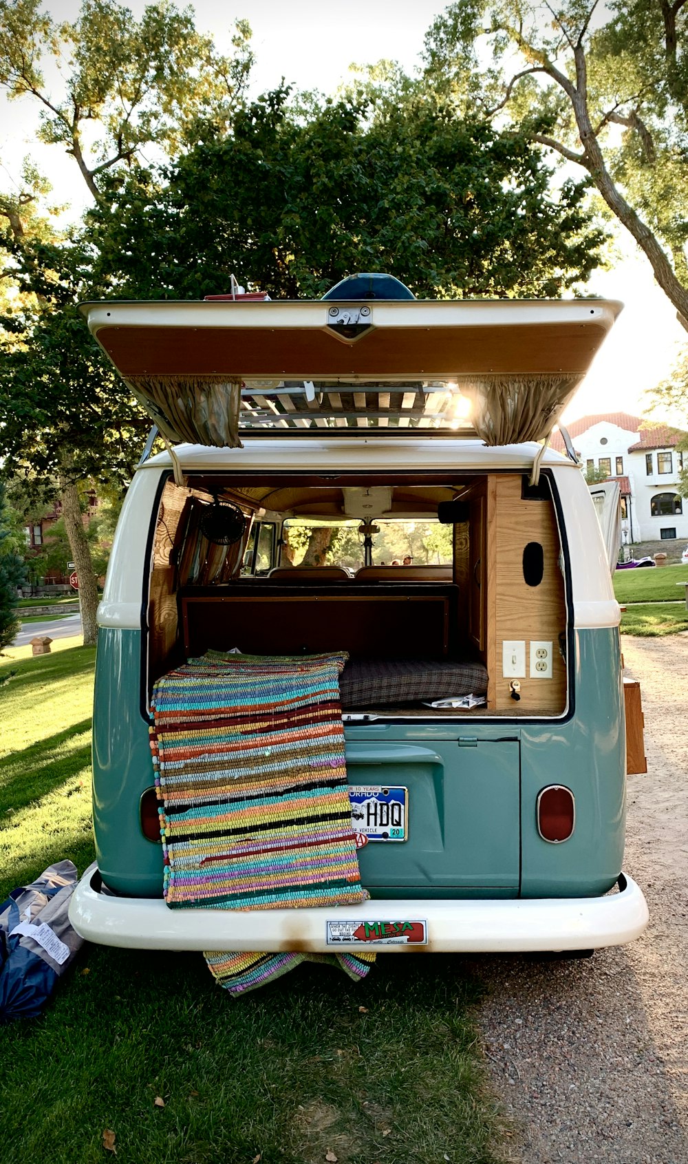 a blue and white vw bus parked in the grass