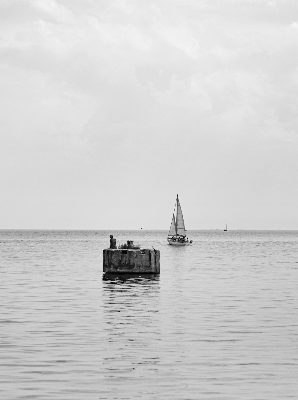 a sailboat and a small boat in a large body of water