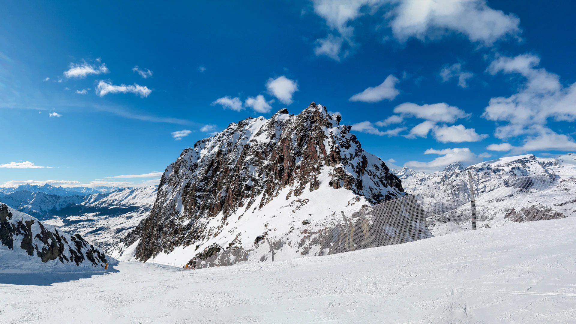 Zonnige skipiste onder een strakblauwe lucht