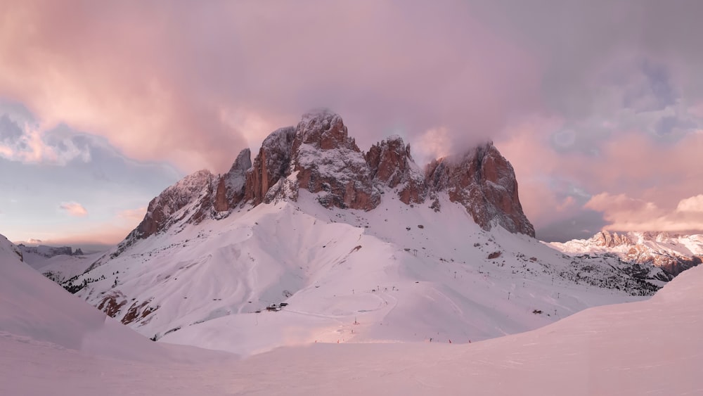 a mountain covered in snow under a cloudy sky